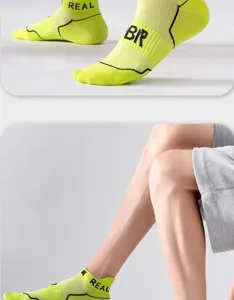 Detailed view of fluorescent yellow athletic short socks with mesh design and knit branding.