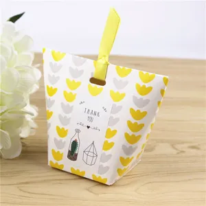 Sac en papier pour bonbons avec motif floral abstrait et ruban jaune pour petits cadeaux.