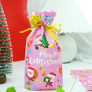 Sac de cadeau plastique rose de Noël avec imprimé père Noël et beau nœud ruban doré.