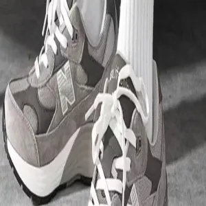 Grey vintage retro running sneakers matched with white ribbed crew socks for daily wear