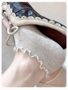 Close-up detail of sheer lettuce-edge ankle socks in beige, breathable spring style.
