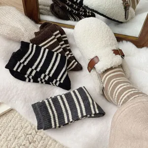 Cozy striped mid-calf socks paired with plush fleece shoes in a warm daily lifestyle detail shot.