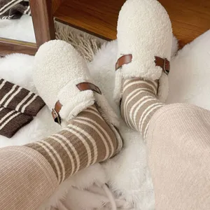 Cozy fluffy sherpa slippers paired with cute winter striped socks for warm homewear style.