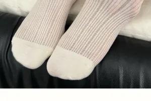 Close-up detail view of white mesh hollow-out socks with vertical ribbed knit texture.
