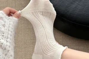 White sheer mesh mid-calf socks with delicate ruffle trim, breathable summer style.