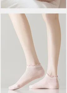 Detalle de calcetines cortos rosas con volantes y patrón de malla acanalada transpirable.