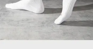 White athletic crew socks detail shot, comfortable cotton fabric with classic ribbed design.