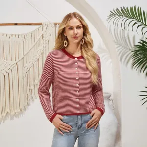Close-up detail shot of the red and white striped cardigan worn by the model in a cozy setting.