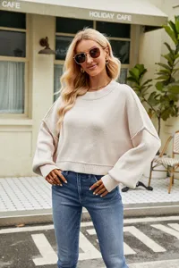 Detailed view of the casual beige knit sweater featuring a cozy crewneck and long sleeves.