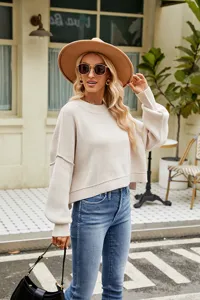 Detail view of casual beige knit sweater featuring long sleeves and cozy round neck design.