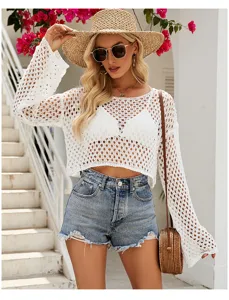 Detailaufnahme eines weißen Häkel-Crop-Tops mit langen Trommelärmeln an einem Modell.