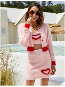 Chic pink knit 3-piece set featuring camisole, cardigan, and skirt with sweet red heart details.