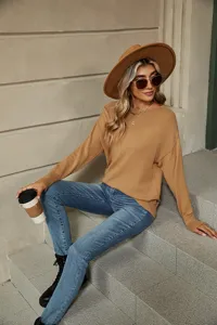 Detail view of the elegant solid color boat neck knit sweater in outdoor lifestyle setting.