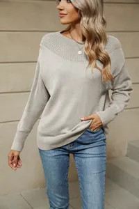 Detail shot of women's solid color boat neck long sleeve knitted sweater textured fabric close up