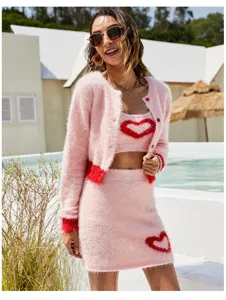 Outdoor resort detail shot of pink fluffy knit three-piece set featuring cute heart pattern.
