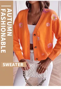 Detail shot of women's orange knitted cardigan with cute daisy embroidery and V-neck.