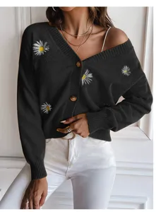 Close-up view of the stylish black cardigan featuring delicate white daisy embroidery and soft fabric.