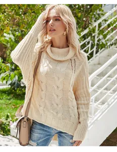 Close-up detail of the beige cable-knit turtleneck sweater featuring batwing sleeves.