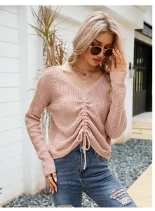 Primer plano del suéter de punto rosa informal con cuello en V y cordón delantero elegante.