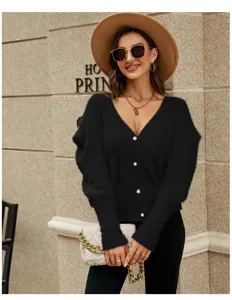 Dettaglio di cardigan in maglia soffice da donna con maniche a palloncino e bottoni perla.