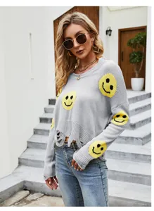 Maglione in maglia grigia consumata con simpatiche faccine smiley gialle, dettaglio maniche lunghe.