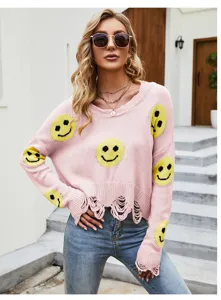 Vista dettagliata del maglione in maglia rosa da donna con simpatici volti sorridenti.
