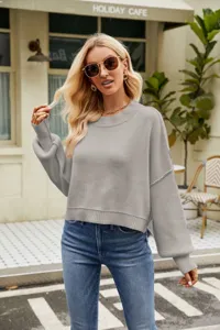 Close-up detail of casual grey long sleeve crewneck knit sweater, solid short pullover style.