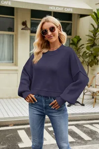 Detail view of the dark purple oversized crewneck knit sweater, cozy long batwing sleeves.