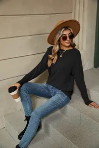 Black knit sweater detail shot showing boat neck design, long sleeves, and casual fit.