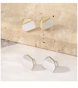 Vue détaillée de boucles d'oreilles géométriques en argent avec nacre blanche.