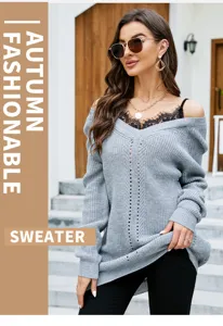 Detailansicht eines grauen V-Ausschnitt Strickpullovers mit Spitzeneinsatz im Freien.