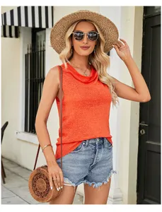 Detail view of the orange sleeveless knit top, showing cowl neck texture and summer styling.