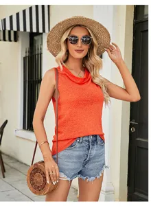 Detailed view of women's orange cowl neck sleeveless knit top worn with denim shorts outdoors.