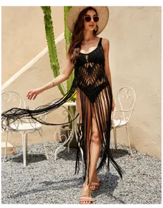 Detailed view of black crochet knit beach cover-up featuring dramatic long fringe and straps.