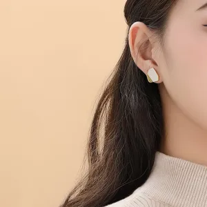 Boucles d'oreilles puces géométriques irrégulières en nacre blanche pour femmes élégantes.