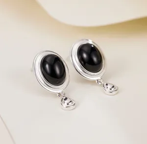 Primer plano de pendientes de plata 925 con ágata negra en un diseño minimalista muy elegante.