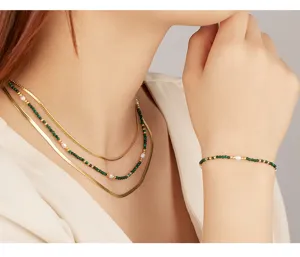 Detail view of layered malachite and snake chain necklaces with matching bracelet for women.
