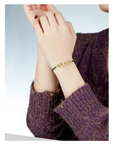 Detailed shot of the retro Chinese style malachite and silver coin bracelet on wrist.