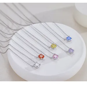 Gros plan détaillé de délicats colliers en argent avec pendentifs en pierres colorées.
