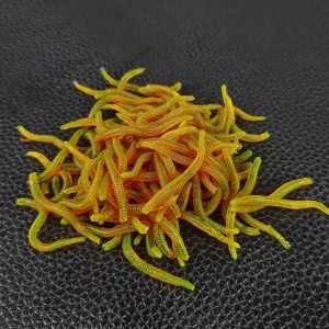 Close-up detail of glowing soft fishing lures, realistic artificial earthworm baits for angling.