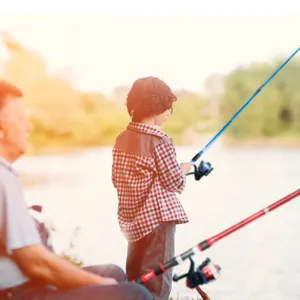 Outdoor fishing scene detail showing a child using a fishing lure rod and reel by the lake side.