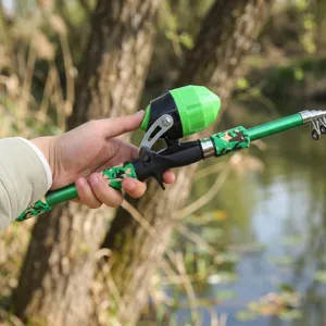 Close-up detail of the portable telescopic fishing rod and reel with camo grip for outdoor fishing.
