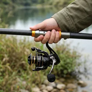 Primer plano del carrete de pesca y mango de caña telescópica, detalle de equipo.