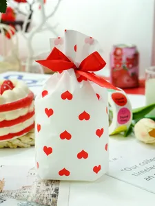 Detailopname van witte plastic cadeauzak met rode harten en lint voor Valentijnsdag.