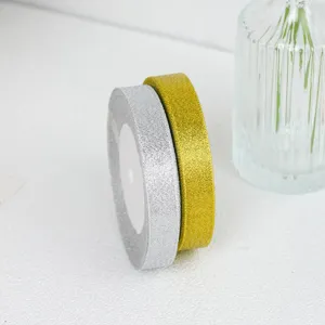 Close-up detail of metallic glitter ribbon rolls in gold and silver, perfect for gift decor.