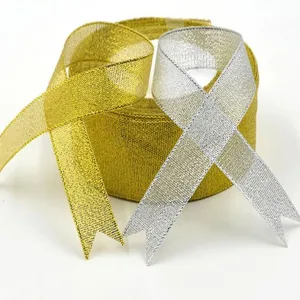 Close-up detail of glittering gold and silver metallic ribbons for gift wrapping and decoration.