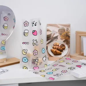 Detailansicht der matten, klaren Geschenktüte mit süßen Cartoon-Blumen und Mustern.
