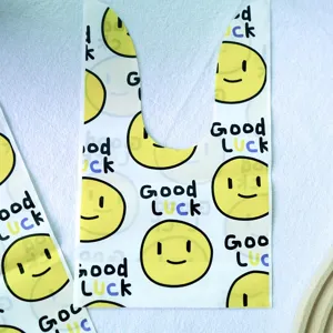 Schuetteltuete mit gelbem Smiley-Gesicht und Hase-Oehrchen, ideal fuer Geschenke und Suessigkeiten.