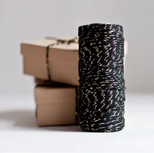 Black and gold metallic cotton twine spool for gift wrapping, crafts and decorative packaging.