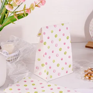 Vista detallada de bolsas de papel de lunares con patrones rosas y verdes para regalos.